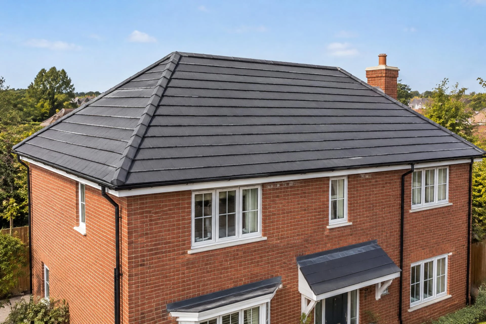Illustrative British red-brick home with a finished pitched tiled roof